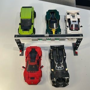 Lego sets combined. 4 race cars, Green truck. finish line. Drivers included